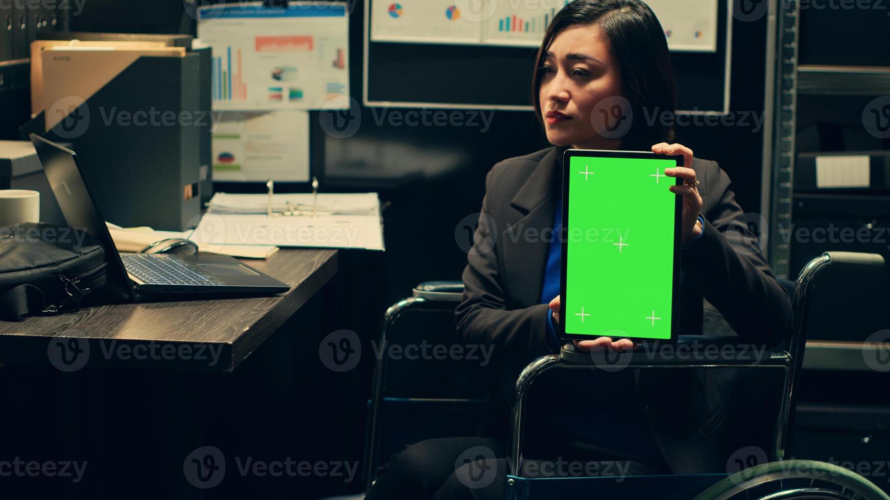 Detective wheelchair user holds greenscreen layout on tablet, using copyspace isolated display on gadget in incident room. Private investigator holding device with mockup screen. Camera A. photo