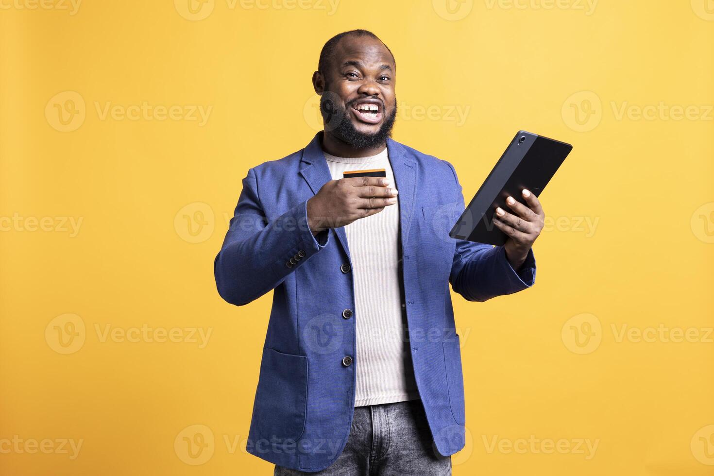 Portrait of elated man adding payment method on website, delighted to take advantage of promotions, studio background. Joyful person thrilled to do internet shopping, typing credit card data on tablet photo
