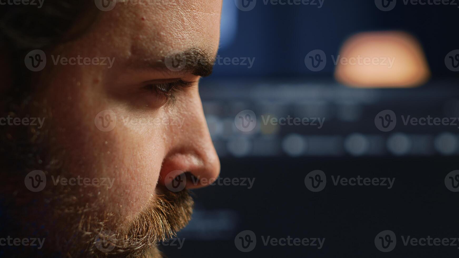 Developer in home office concentrating hard while doing coding on computer, extreme close up shot. Focus on IT admin paying close attention to screen while writing lines of code, camera A photo