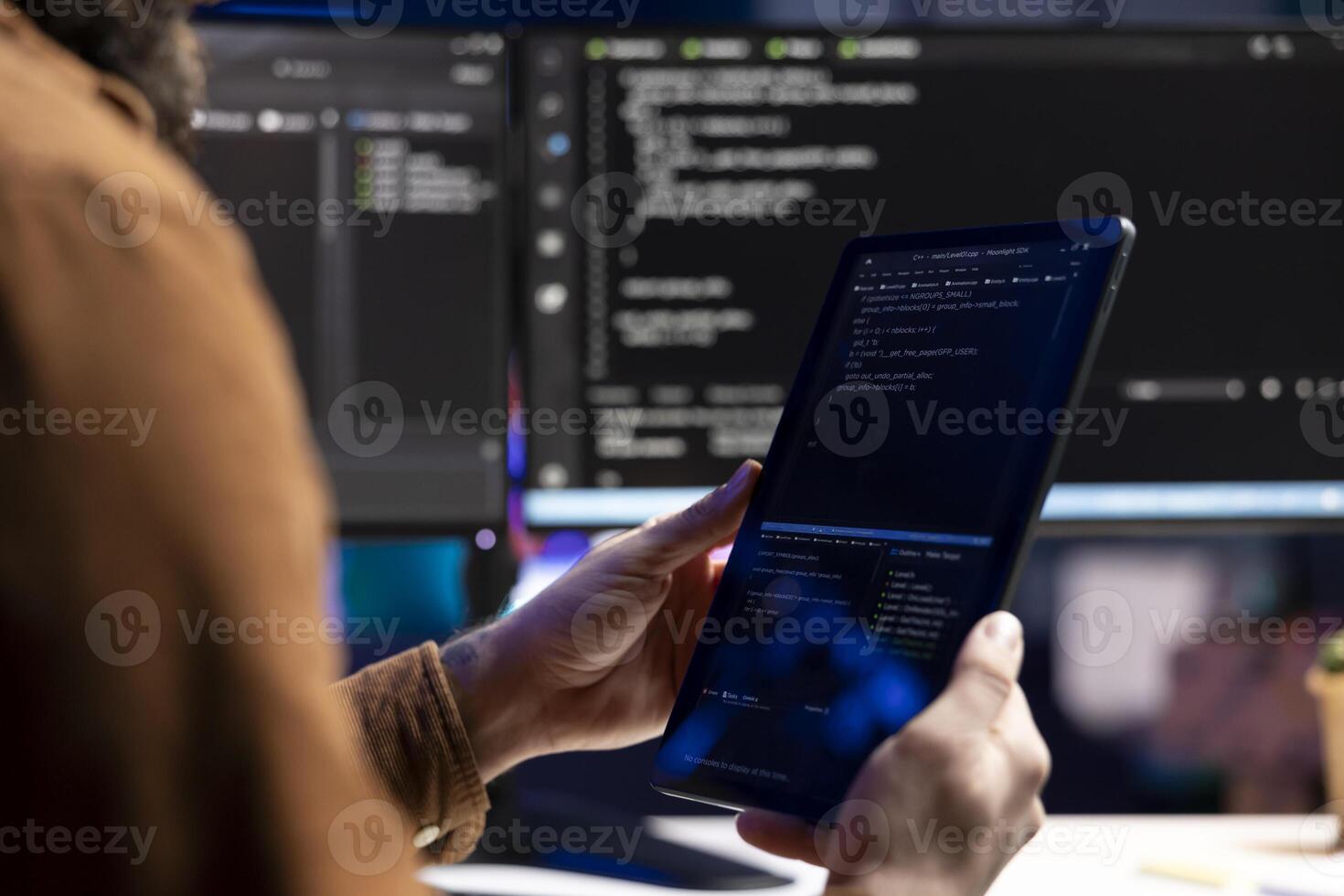Computer scientist doing software quality assurance using tablet, reading source code before implementing it. Developer inspecting coding on portable device, looking to fix potential issues photo