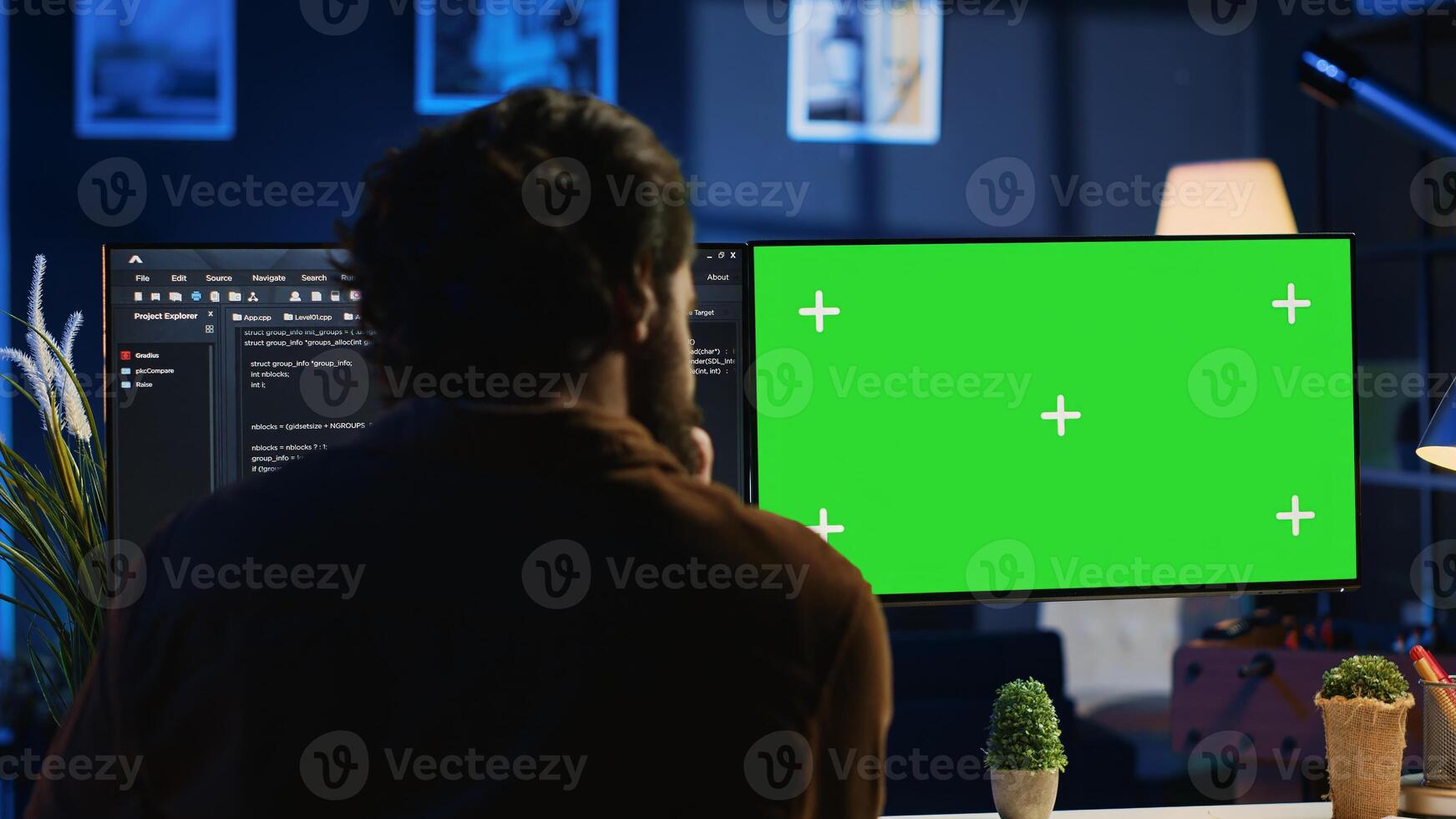 Programmer typing complex code on green screen computer in neon lit home office, developing software application. Teleworking IT specialist doing remote project tasks on mockup PC monitor, camera A photo