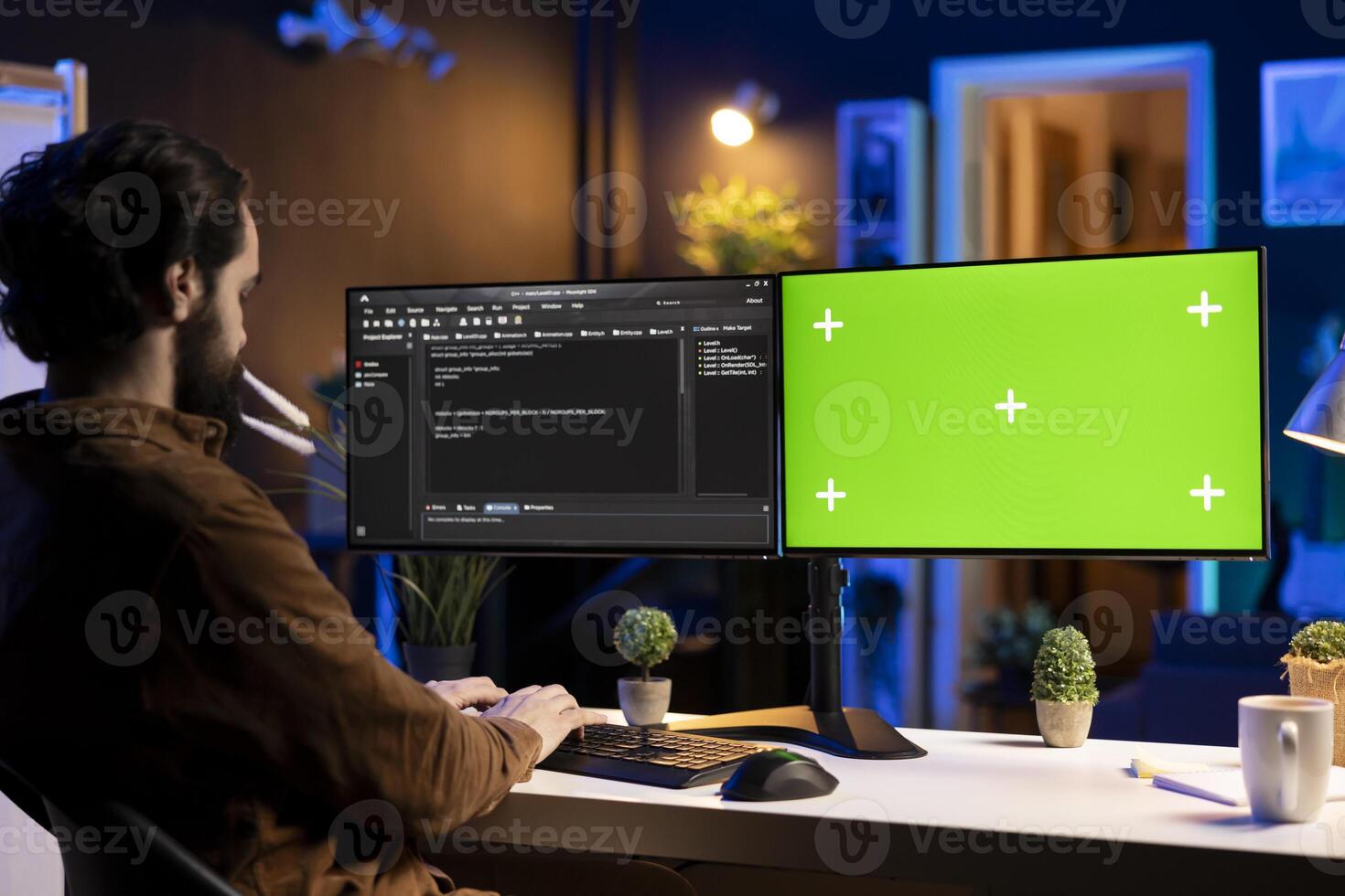 Freelancing admin using green screen computer monitors to filter malicious traffic from cybercriminals attempting to corrupt company data. IT expert in apartment working on mockup desktop PC photo