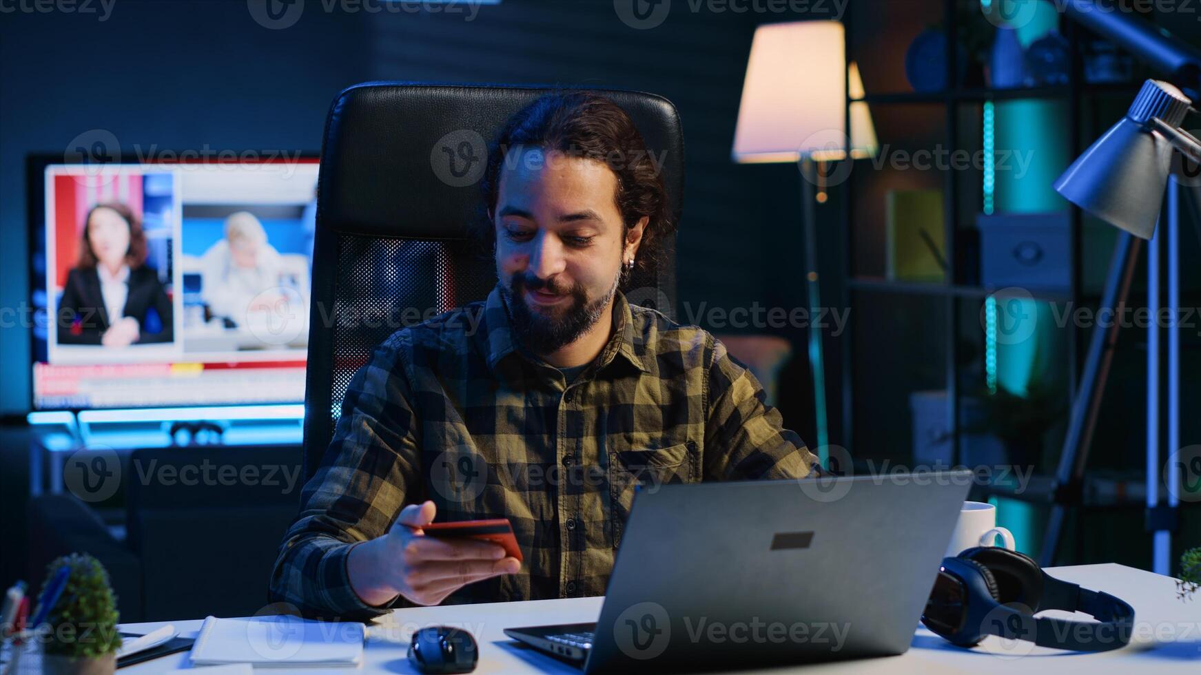 Happy man doing internet shopping, carefully typing credit card information on laptop in apartment. Smiling person adding payment method on website while in living room, camera A photo