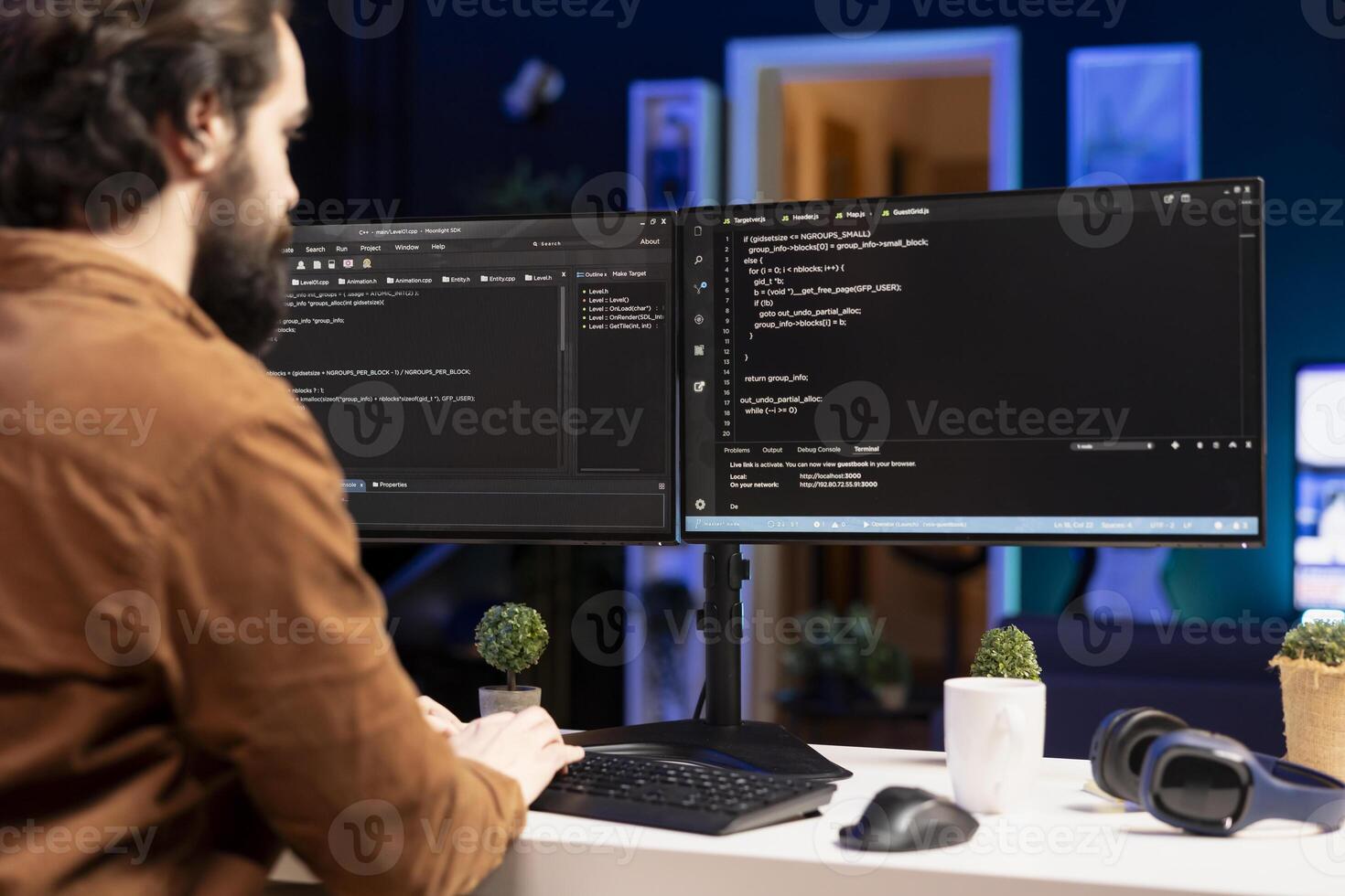 IT expert working from home developing software in JavaScript programming language using desktop PC. System engineer in living room writing lines of code on computer using keyboard photo