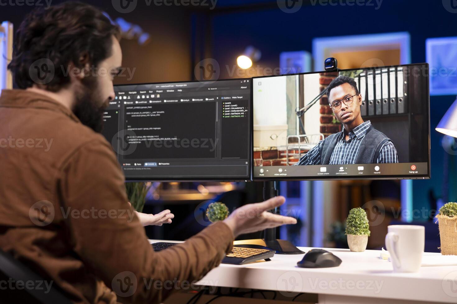 Programmer doing software debugging helped by coworker in videocall, checking errors in lines of code. Man working from home fixing coding mistakes, assisted by colleague in teleconference photo