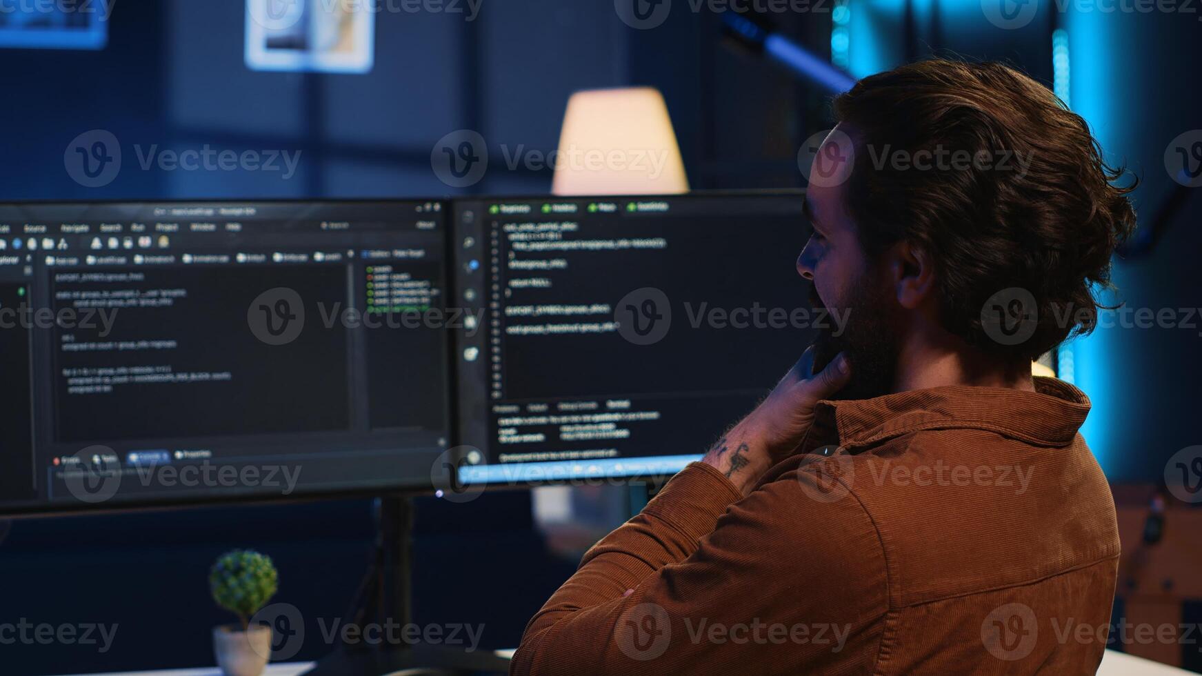 Happy self employed developer in home office doing coding on computer at desk. Joyful IT specialist doing contracted job from apartment, writing lines of code at workstation, camera A photo