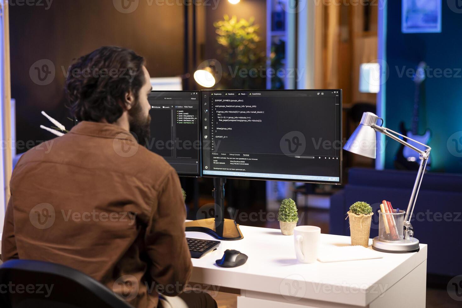Computer operator doing software debugging on PC at home, checking broken lines of code displayed on monitors. IT expert in apartment fixing coding problems, typing on keyboard photo