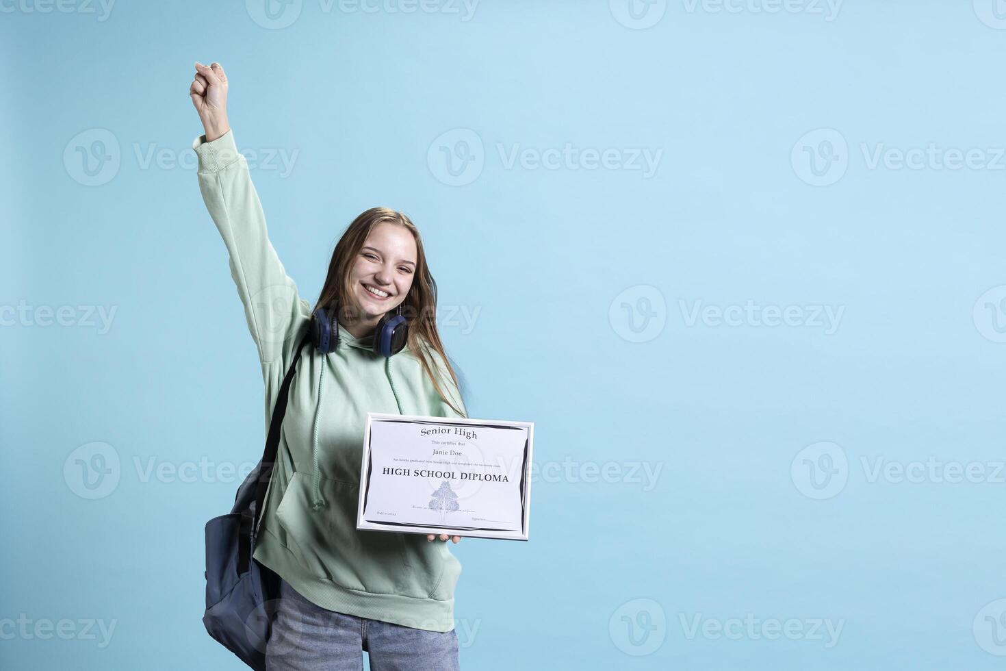Portrait of smiling student holding high school diploma, feeling overjoyed and celebrating graduating classes with high marks. Cheerful young girl delighted about achievement, studio background photo
