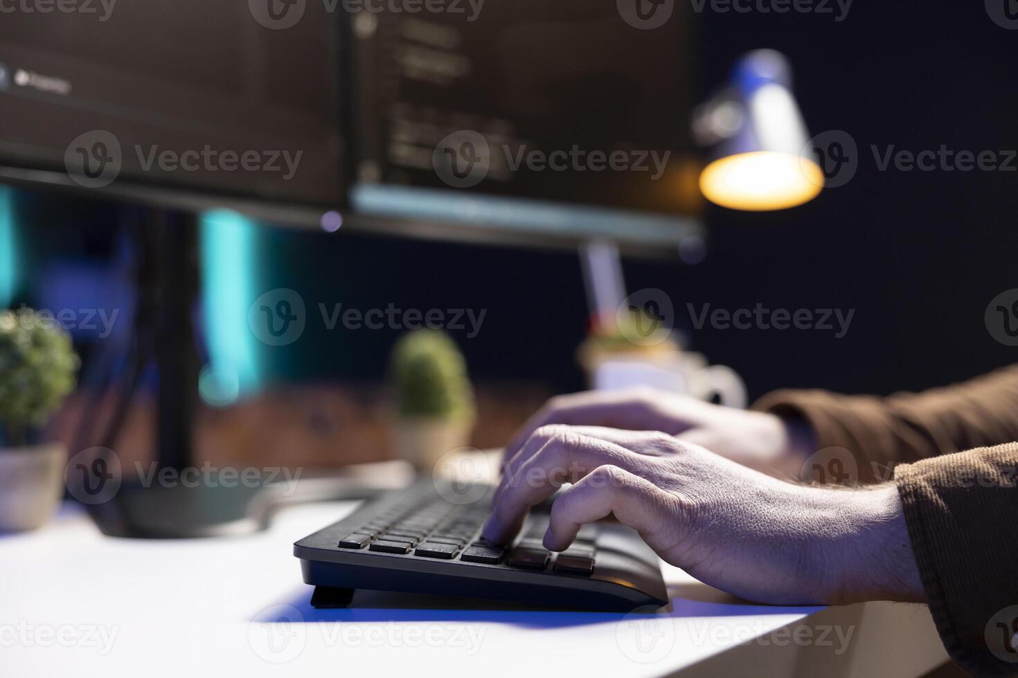 Programmer typing on keyboard, implementing and maintaining security measures to protect company systems and data. Expert writing, testing and debugging Java code for software applications, close up photo