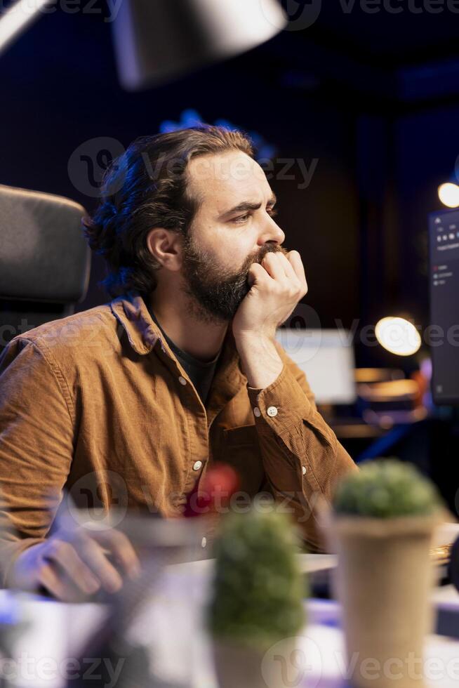 Programmer dismayed by malicious traffic from cybercriminals attempting to steal company data, struggling to filter them. Man shaken by malware attacks, trying to come up with prevention methods photo