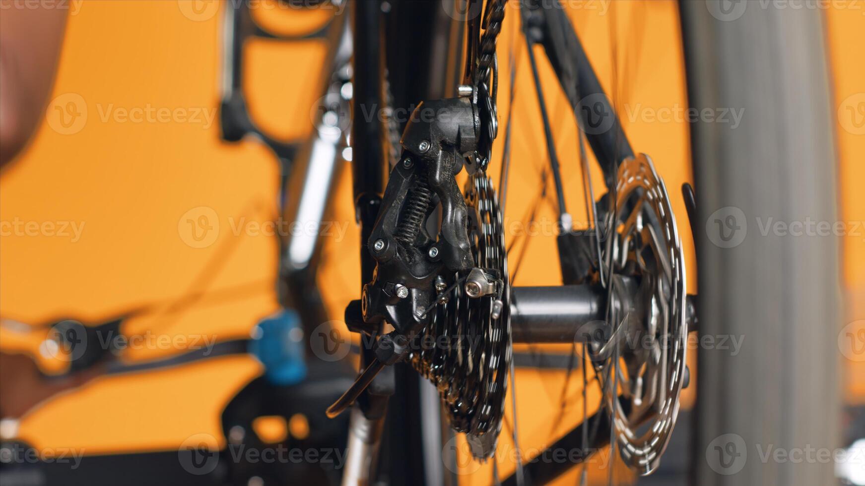 Close up shot of bicycle wheel mechanism being examined by woman during performance assessment. Focus on bike components tested by professional in blurry background ensuring proper function photo
