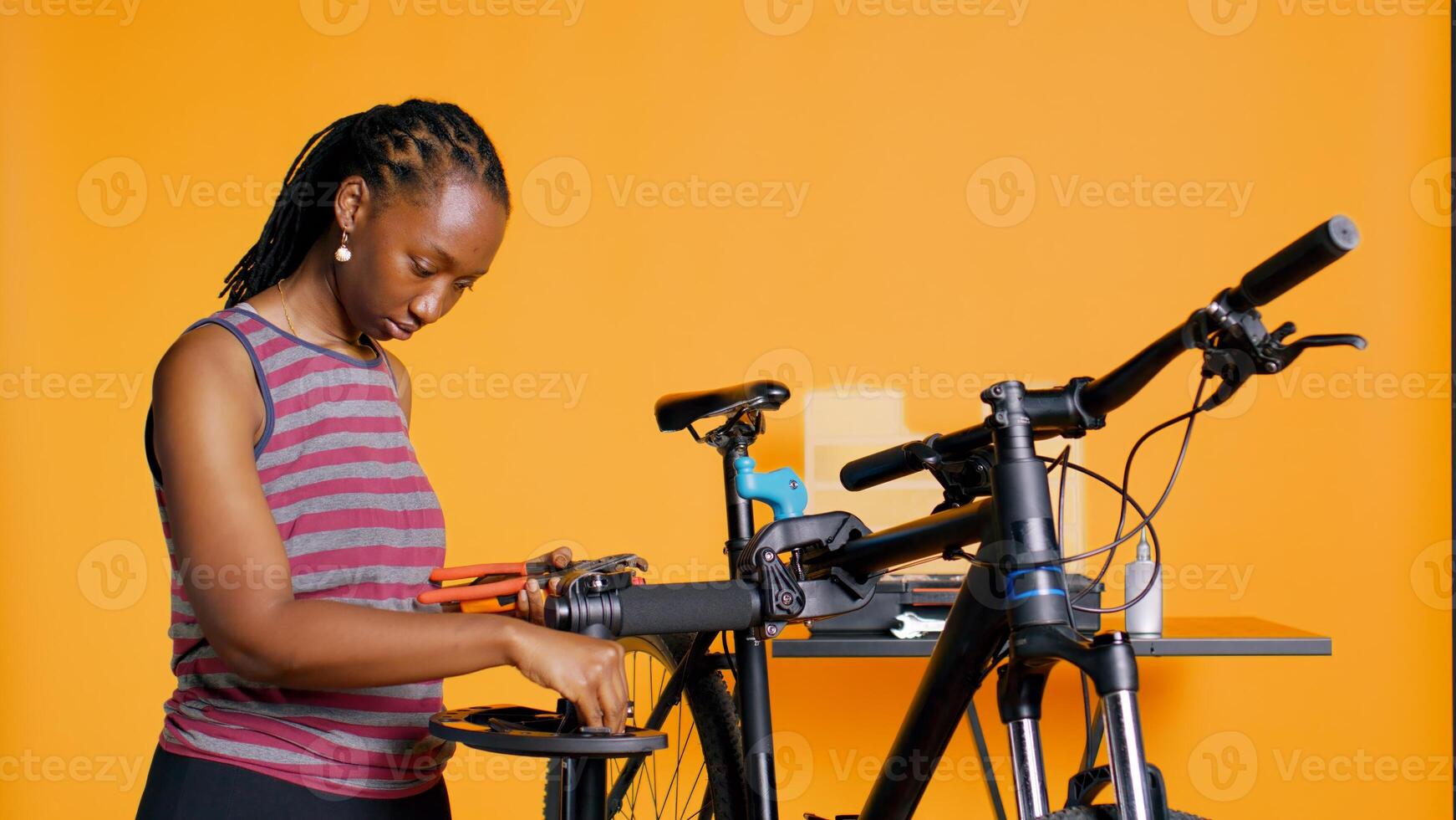 African american mechanic preparing work tools before starting repairing broken client bicycle, studio background. Professional arranging mechanical equipment, ready to start fixing bike, camera B photo