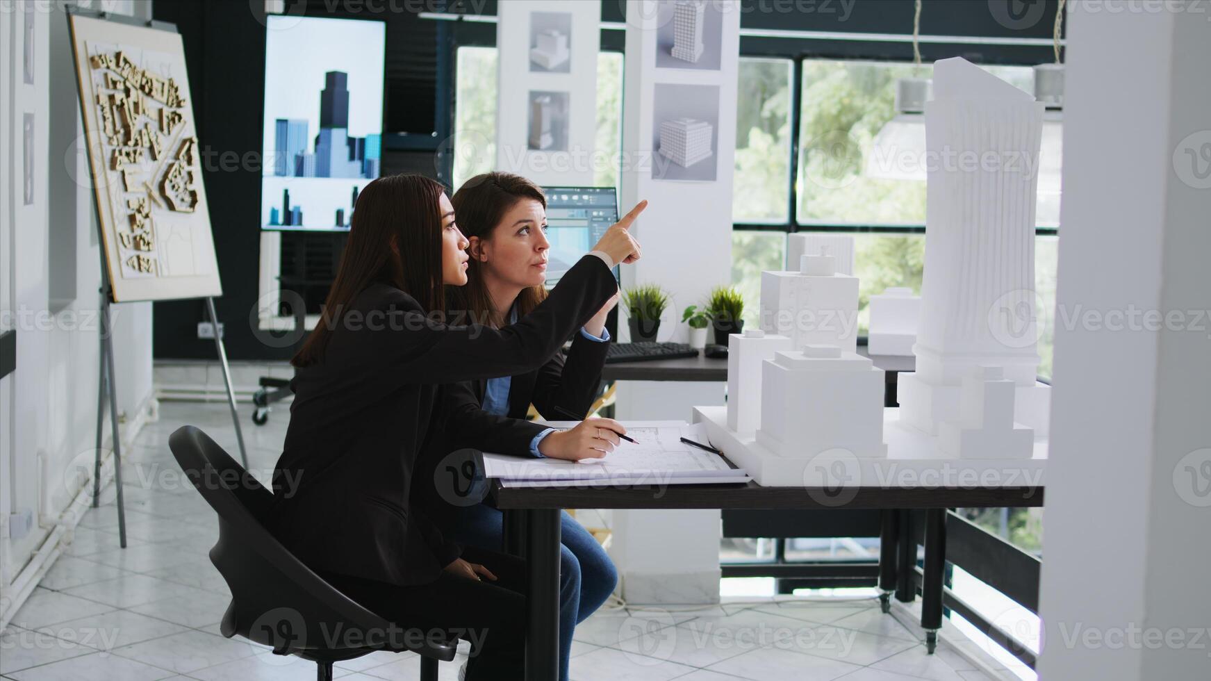 Realty business staff develop architectural schematics using 3D building representation of the original location. Engineers working at startup firm to design a new residential area. Tripod shot. photo