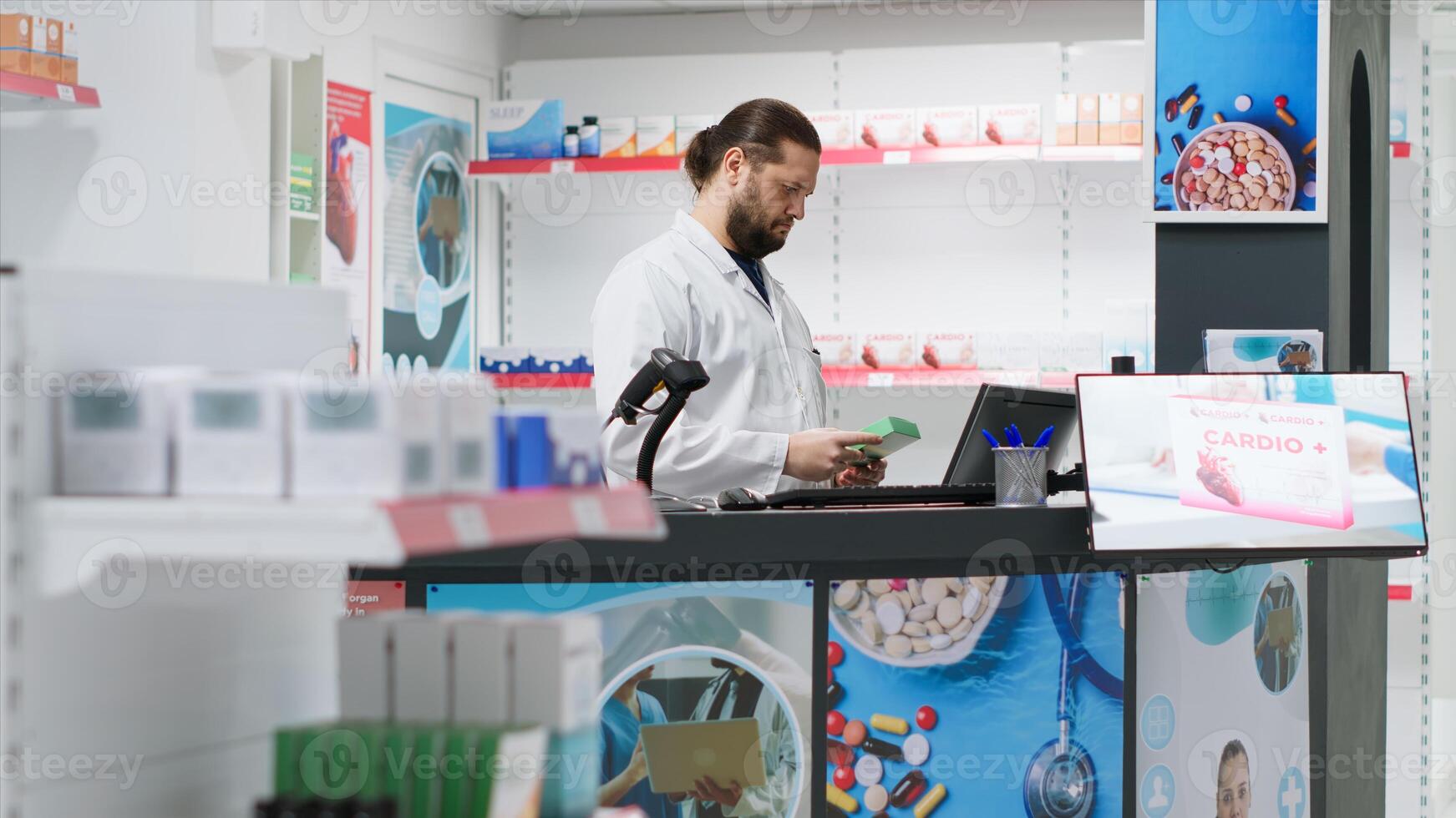 Male pharmacist using scanner to register new stock at counter, working at pharmacy checkout to ensure medicaments and supplements inventory. Employee scanning pharmaceutics in store. photo