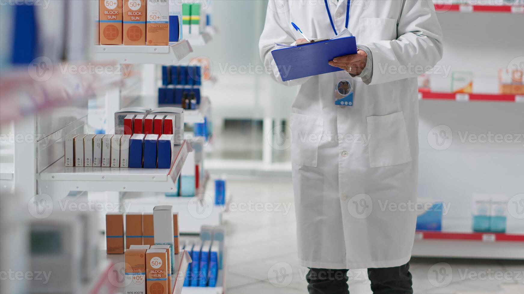 Druggist counting all pharmaceutical stock in pharmacy shop, working on inventory with checklist on clipboard. Pharmacist examining medical products on drugstore shelves. Camera 2. photo