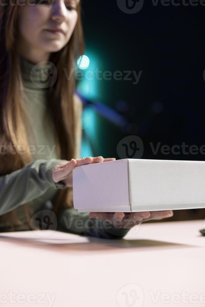Gen Z entertainer recording unboxing of various electronics, presenting features to viewers, close up. Teenage internet star showing product recommendations to fans on social media photo