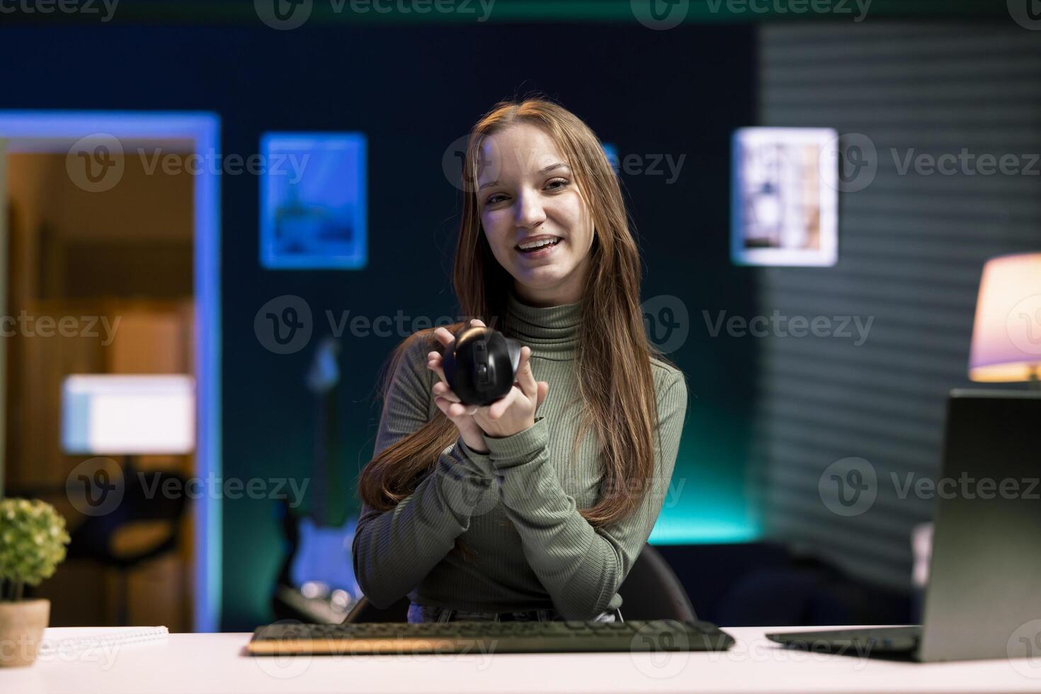 Content creator presenting mouse from brand sponsoring , urging viewers to buy it. Online star does influencer marketing by advertising computer peripherals to audience photo