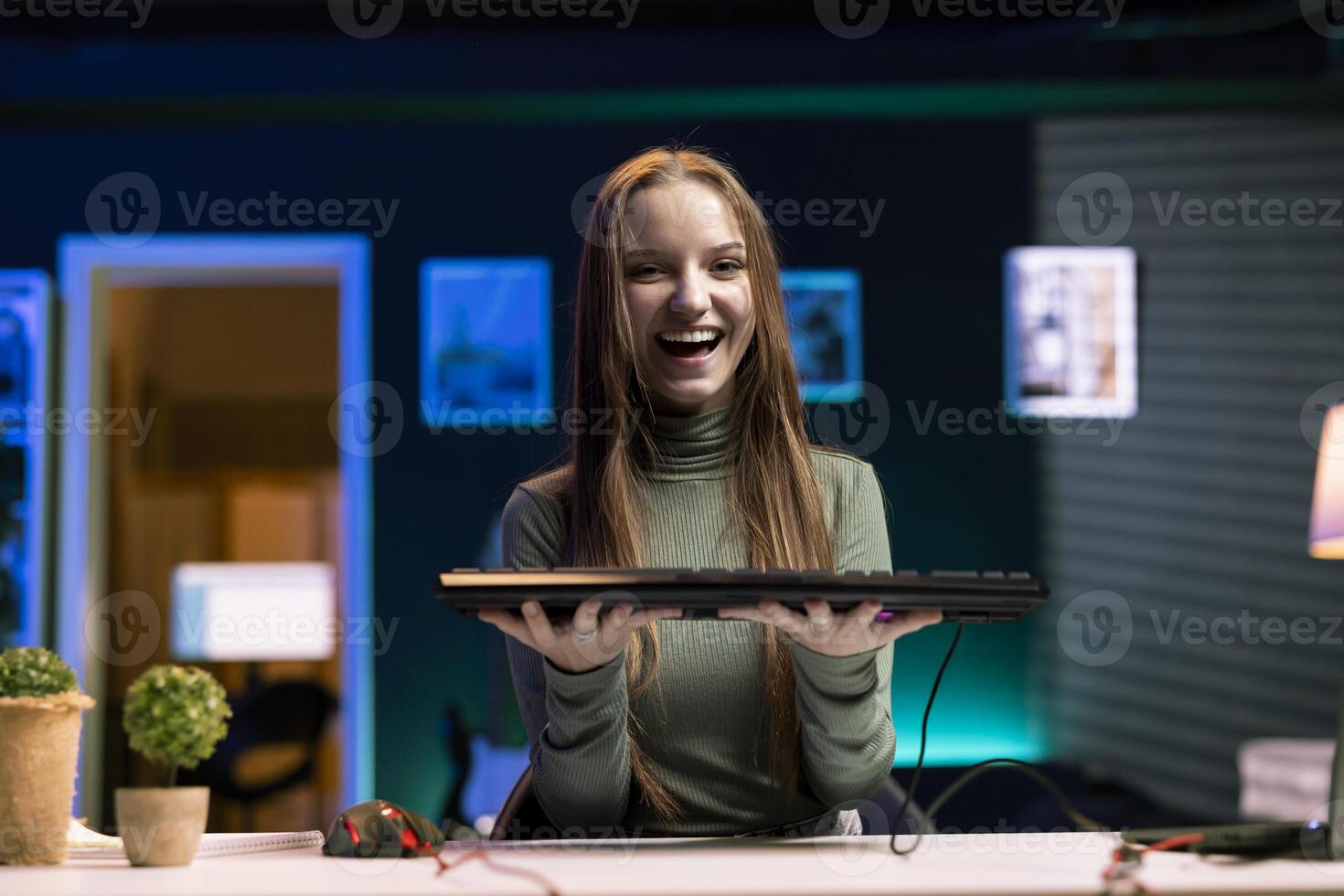 Happy girl excited to analyze mechanical keyboard received from sponsor, doing honest review for online streaming channel. Joyful internet show host excited to review computer peripherals brand photo