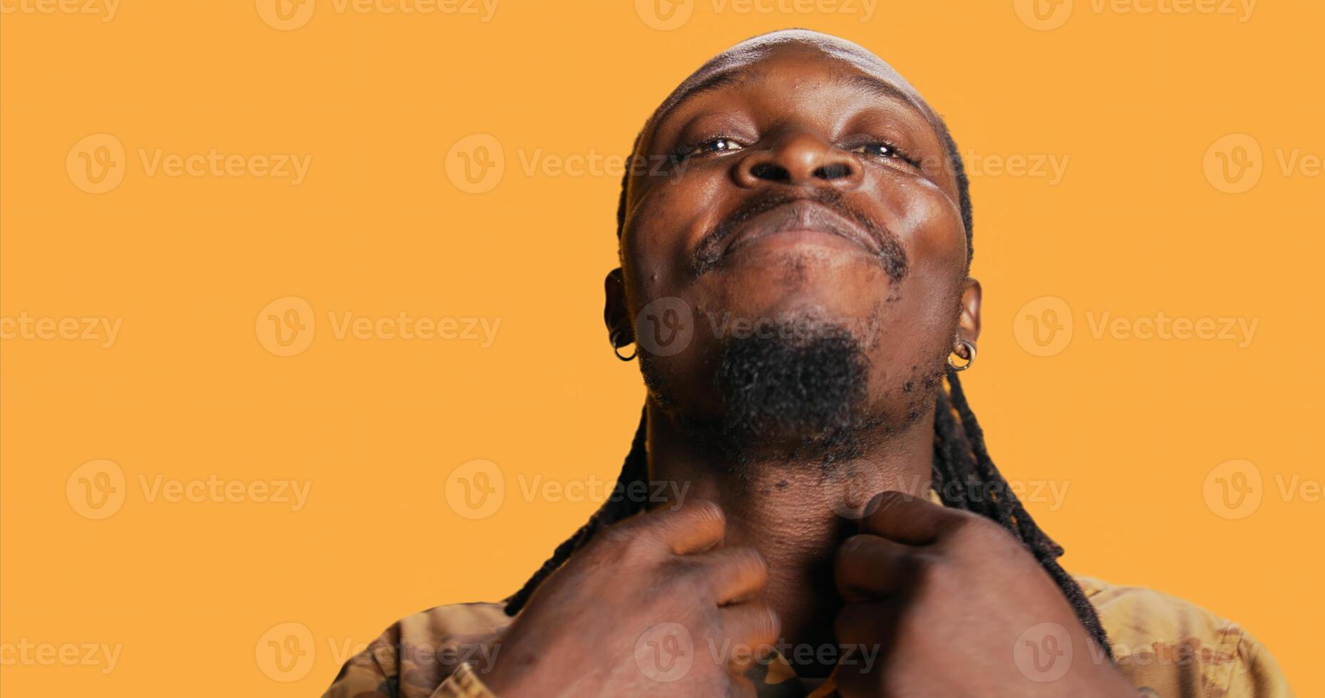 POV of african american guy looks at his reflection in the mirror, arranging his beard and dreads to be confident and trendy. Modern adult is looking at himself and feeling good. Tripod shot. photo
