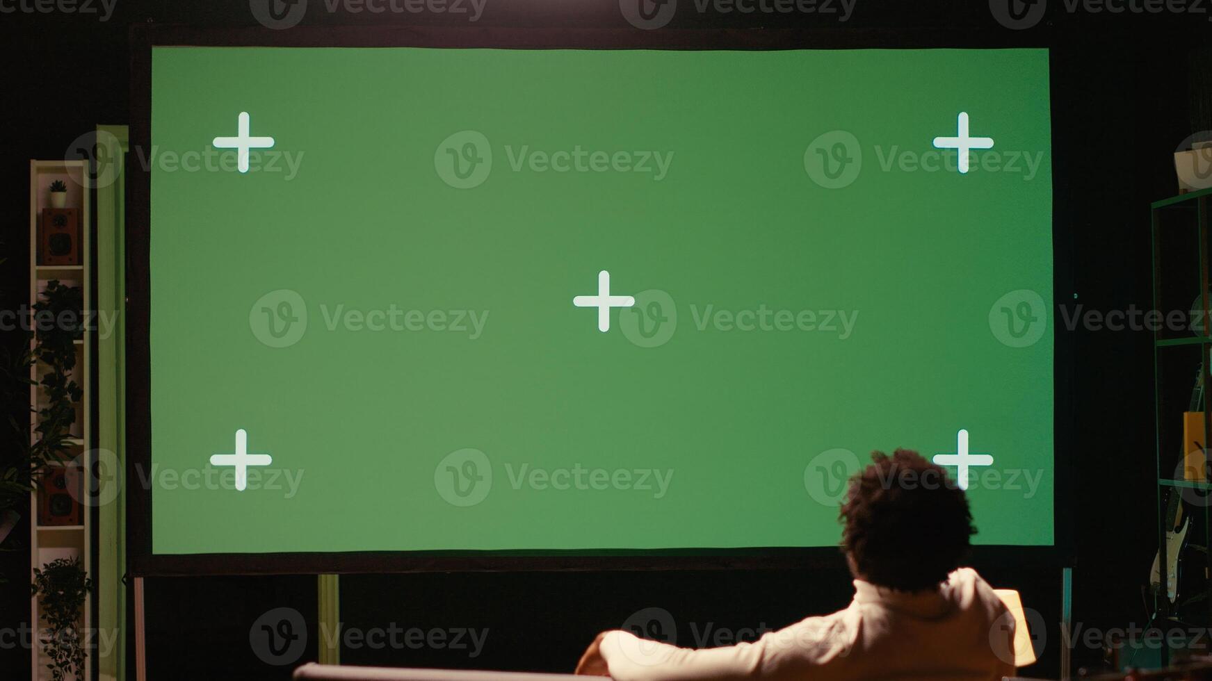 Man using green screen modern TV to watch news program broadcasting in living room. Person watching mockup ultrawide television display showing VOD channel, relaxing on couch photo