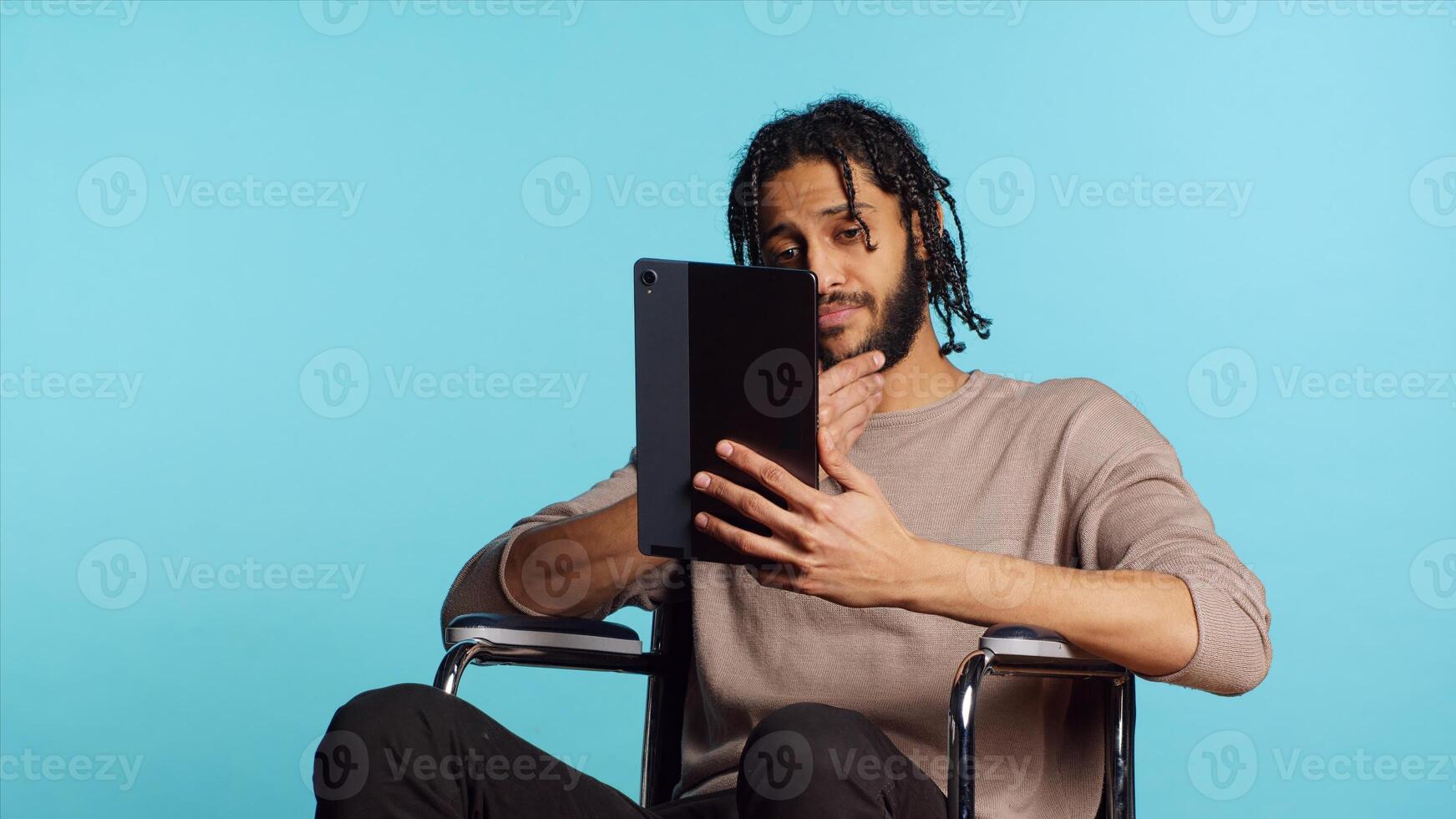 Artist in wheelchair holding tablet, using tactile touchscreen to draw. Person with disability doing digital art on drawing portable device, enjoying hobby in studio background, camera A photo