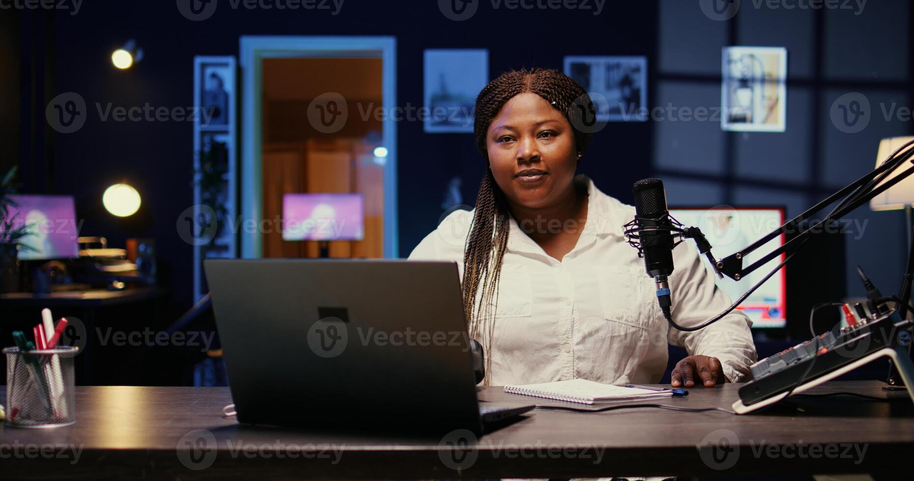 Portrait of african american woman starting live broadcast on streaming platform using professional gear. Influencer arriving in studio, ready to create content for her audience photo