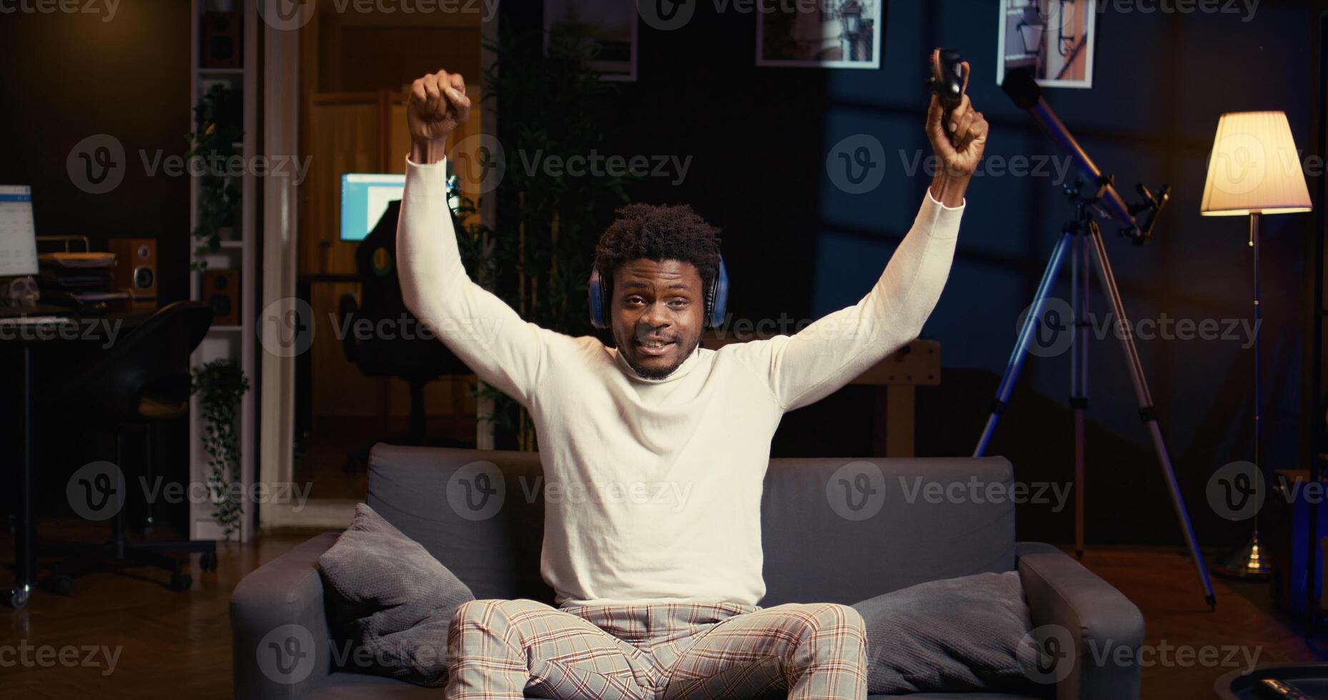 Happy gamer feeling relieved after finally receiving winner screen for killing all enemies in first person shooter, celebrating. Satisfied player congratulating himself after finishing videogame photo