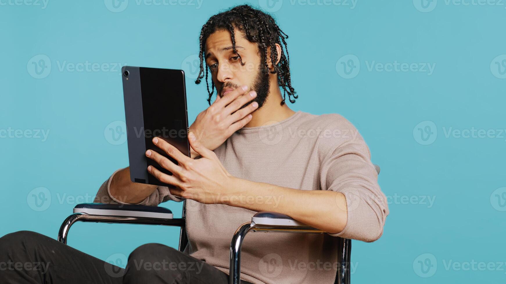 Artist in wheelchair holding tablet, using tactile touchscreen to draw. Person with disability doing digital art on drawing portable device, enjoying hobby in studio background, camera B photo