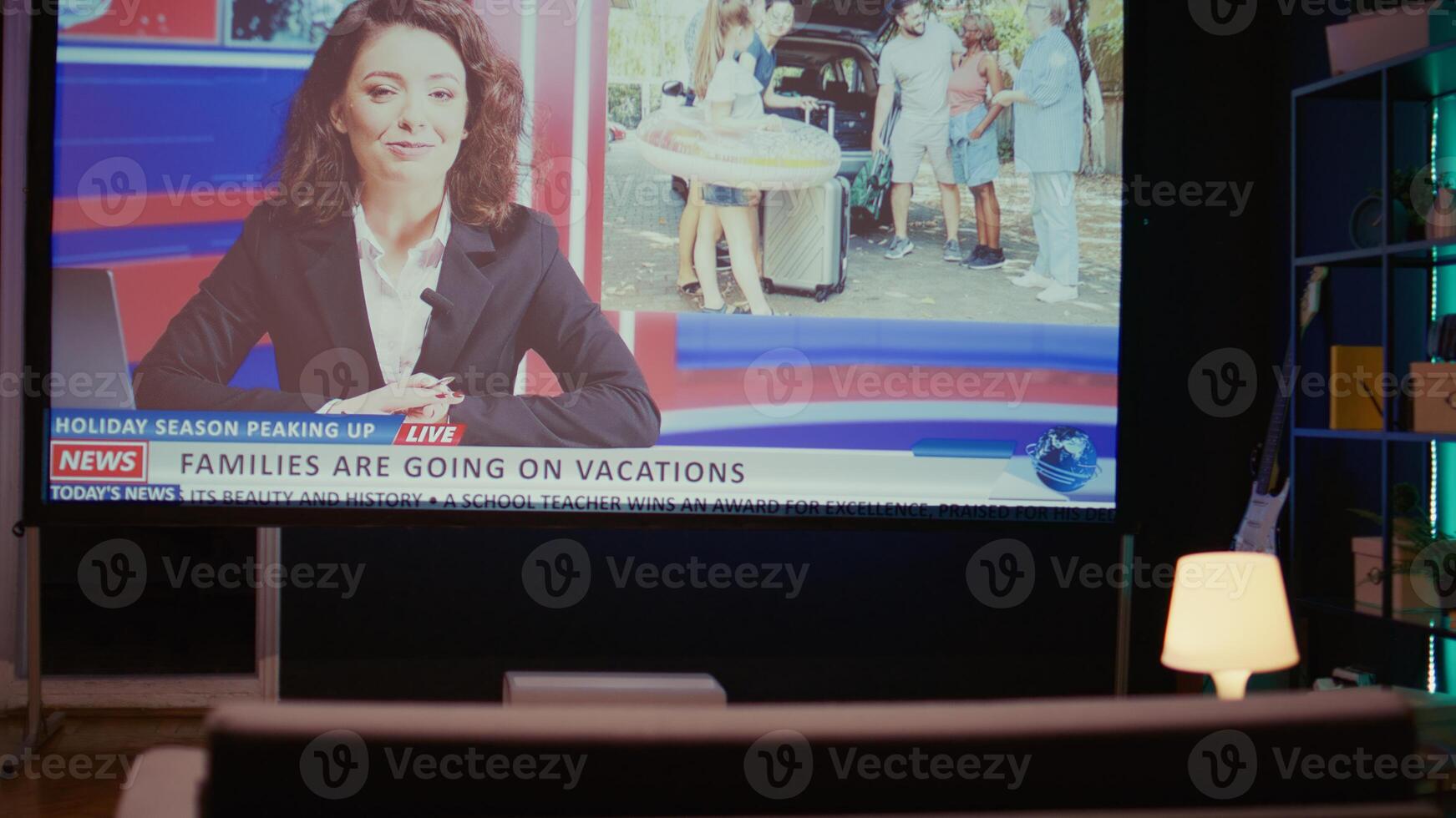 Large TV screen showing news broadcast reportages on summer vacations and family trips. Streaming service travelling channel on widescreen television set left turned on, panning shot photo