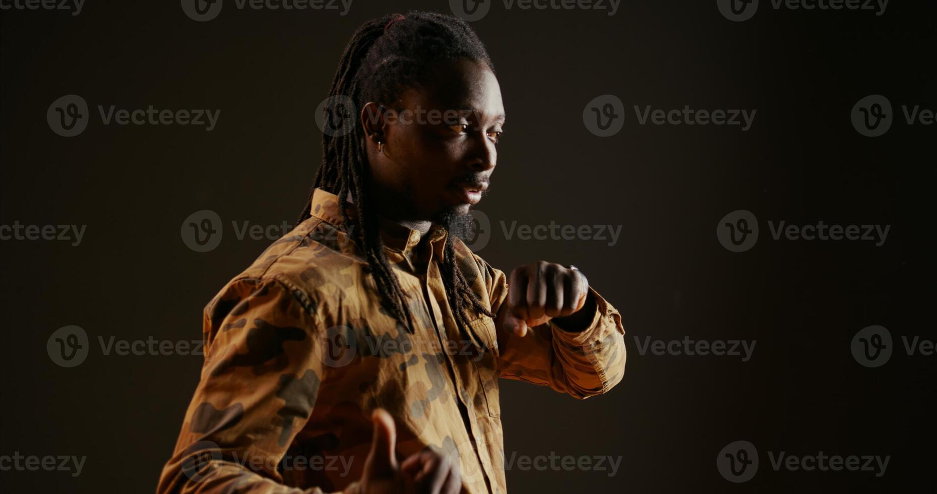 Cool person chatting on phone call using smartwatch, answering call and having remote conversation over black background. Trendy guy enjoys his modern wristwatch, telecommunications. photo