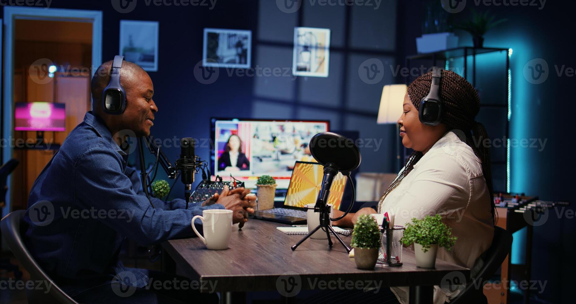 Content creator enjoying nice conversation with guest during podcast. Host enjoying coffee together with cheerful woman live in apartment studio during internet show, zoom out shot photo