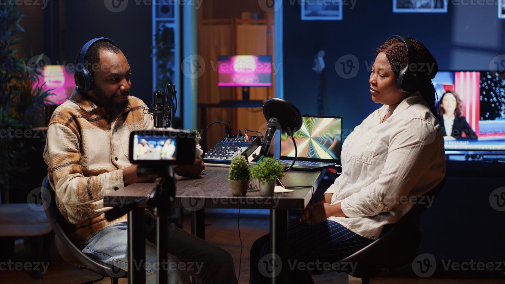 Radio show presenter using professional camera to record live conversation with man in personal studio. Influencer talking with woman, sharing interesting facts for fans at home photo