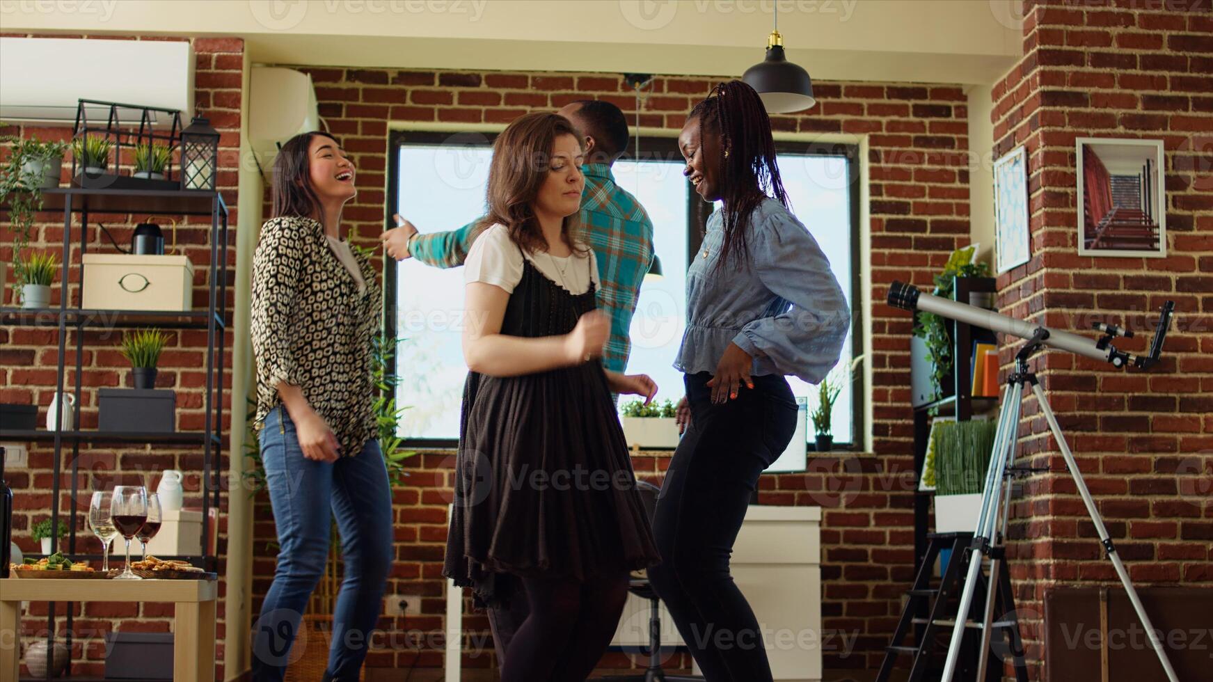 BIPOC school colleagues organizing apartment party, enthusiastically dancing to electronic songs. Friends enjoying time spent together, busting into animated dance moves, tilt up shot photo