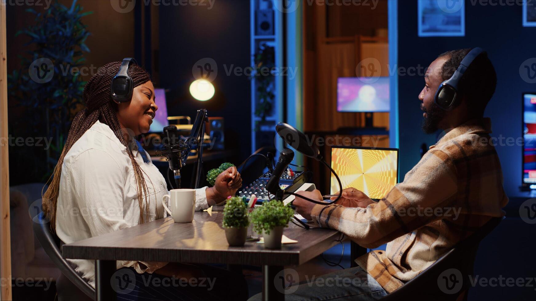 Podcast host having discussion with man, checking analog mixer to make sure audio is impeccable for audience listening at home. Influencer enjoying chat with guest, ensuring sound quality is perfect photo