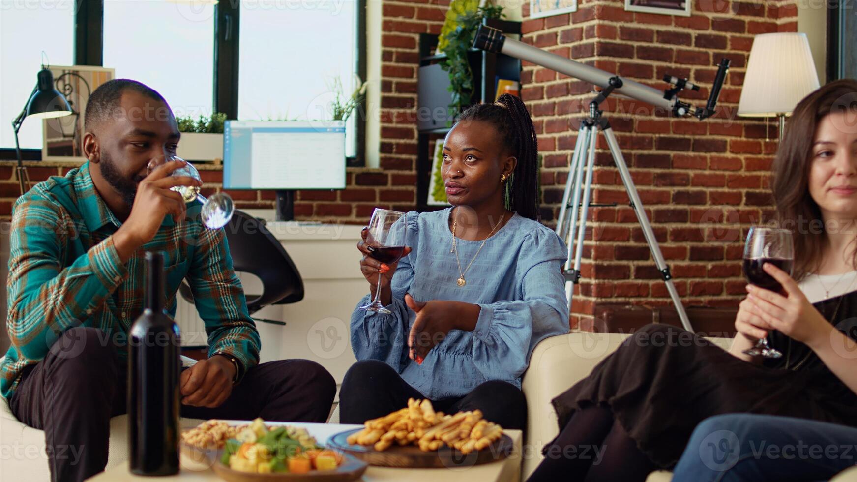 BIPOC friends having entertaining conversation, eating bread sticks from charcuterie board at home. African american, asian and caucasian people throwing party in cozy apartment photo