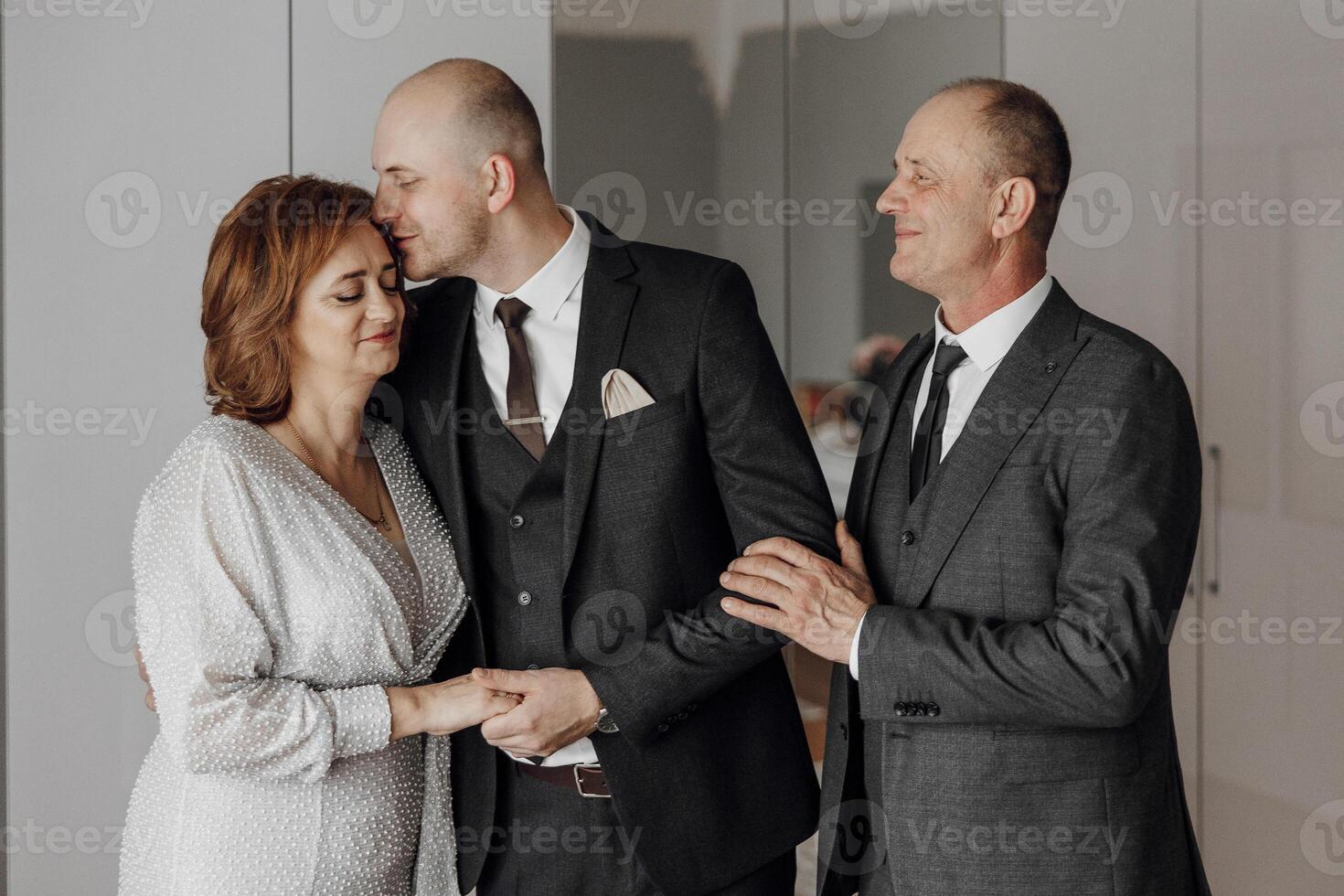 A man and a woman are hugging a man in a suit photo