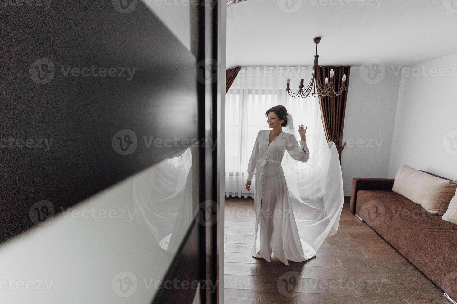 A woman in a wedding dress is standing in a room with a chandelier. The room is dimly lit, and the woman is dancing. Scene is romantic and celebratory photo