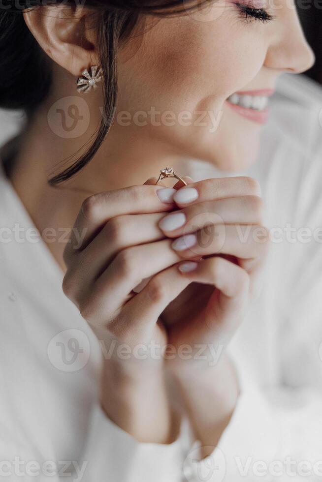 A woman is holding a ring in her hand and smiling. Concept of happiness and joy, as the woman is excited about the ring. The ring itself is a symbol of love and commitment photo