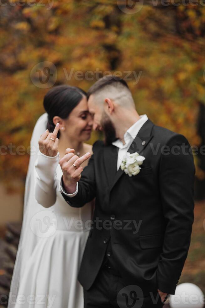 A bride and groom are posing for a picture with their hands together and the bride is giving the man a thumbs up photo