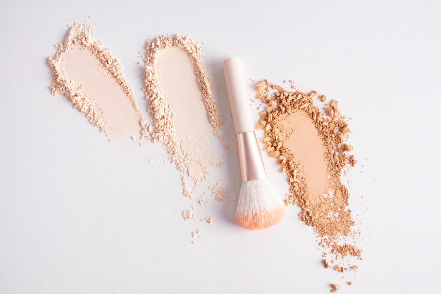 Three beautiful loose powder samples in different tones on a white background and a makeup brush. Upper view. Powder texture mockup. cosmetic. photo