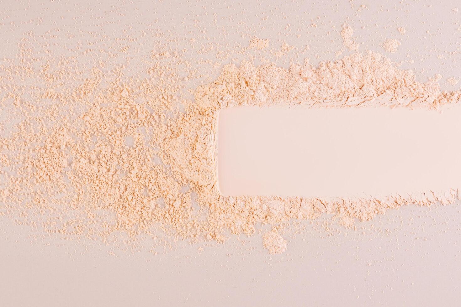 A sample, a stripe, an imprint of loose powder of a natural tone on a beige background. Delicate texture. Breathable powder without weighing it down photo