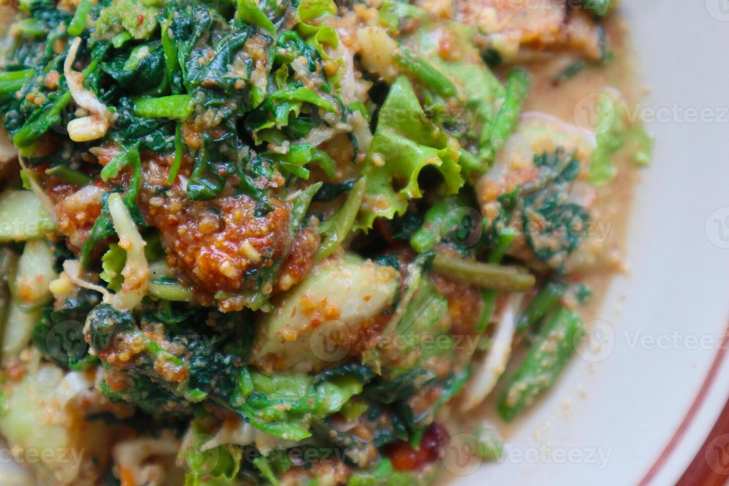 lotek is a traditional salad from Indonesia made from vegetable, chayote, kale, young jackfruit, tempeh, tofu, long beans, and bean sprouts with peanut sauce and cracker photo