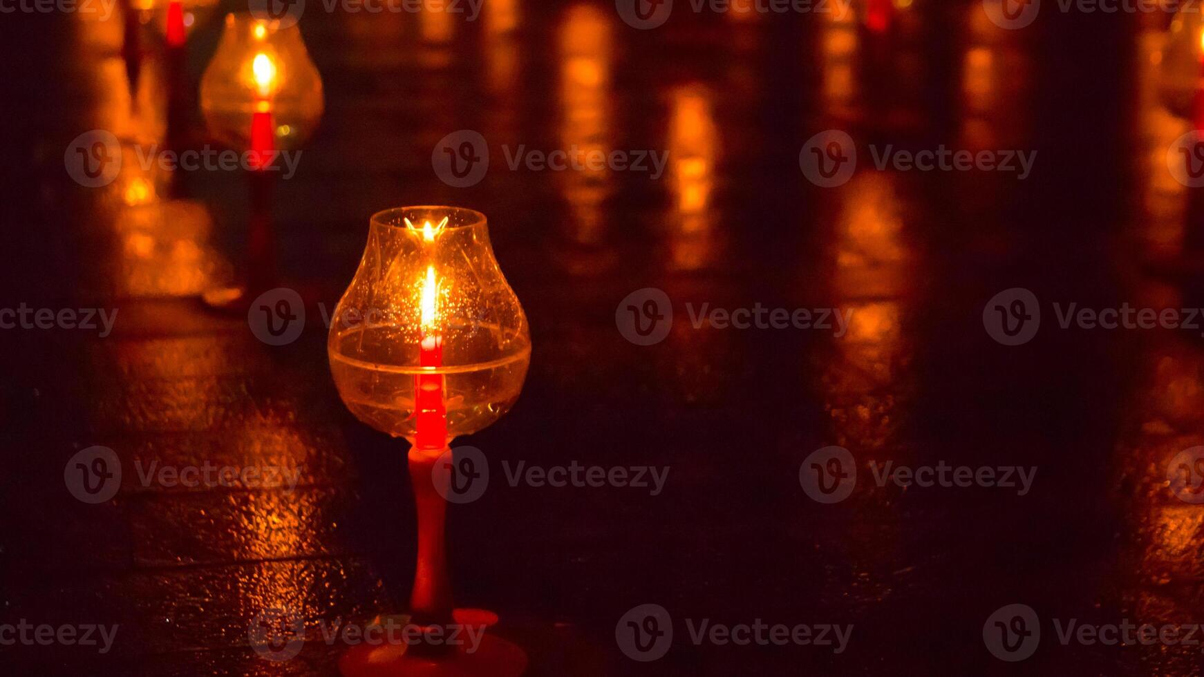 A large number of candles are lit at borobudur temple. The candles are arranged in a pattern, with some candles grouped together and others spaced apart. Scene is one of warmth and coziness photo