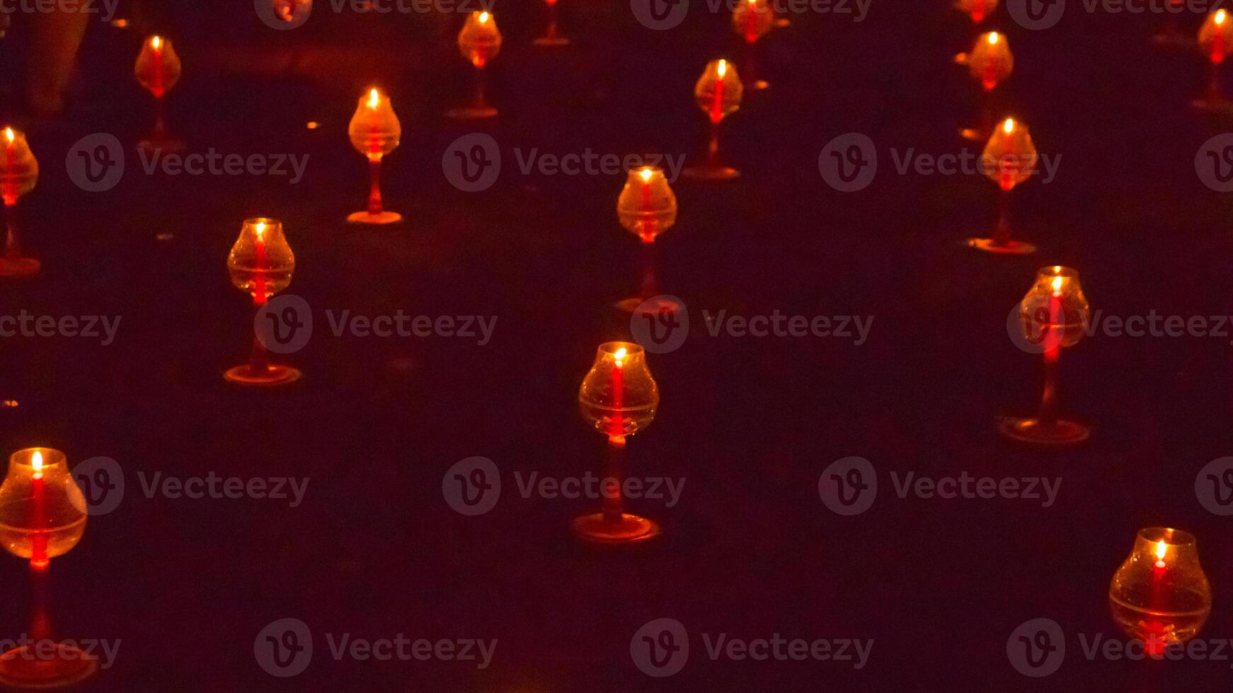 A large number of candles are lit at borobudur temple. The candles are arranged in a pattern, with some candles grouped together and others spaced apart. Scene is one of warmth and coziness photo