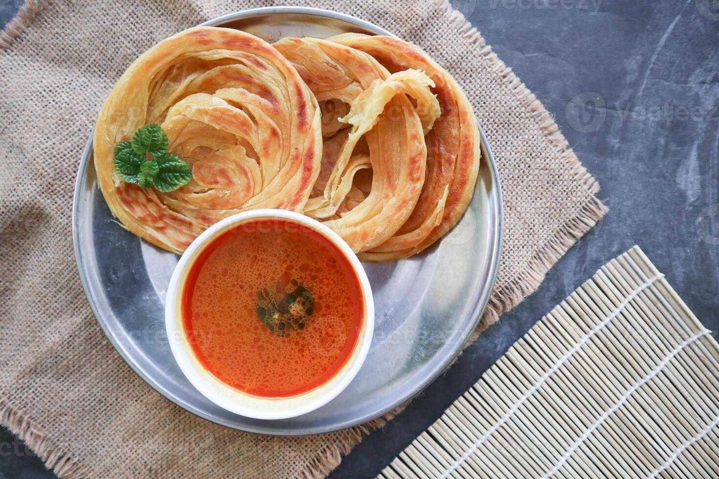 Roti Canai or Paratha Bread with Curry Sauce, Chilli Flakes and Yogurt, Top View photo