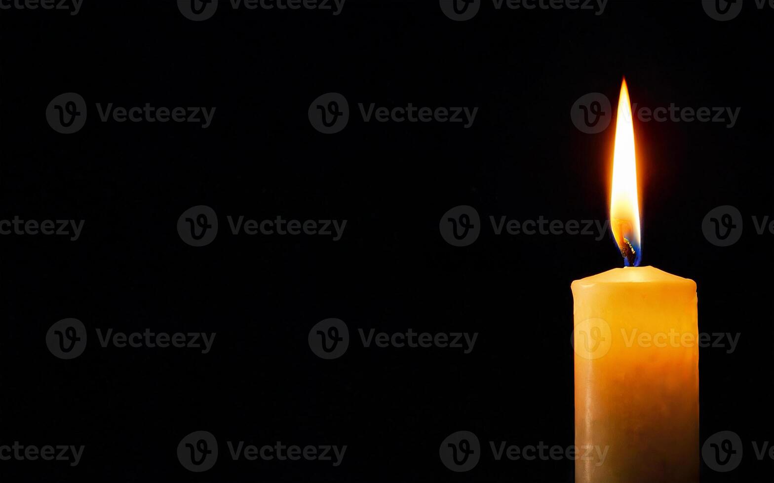 one burning candle on a black background with space for text close-up photo