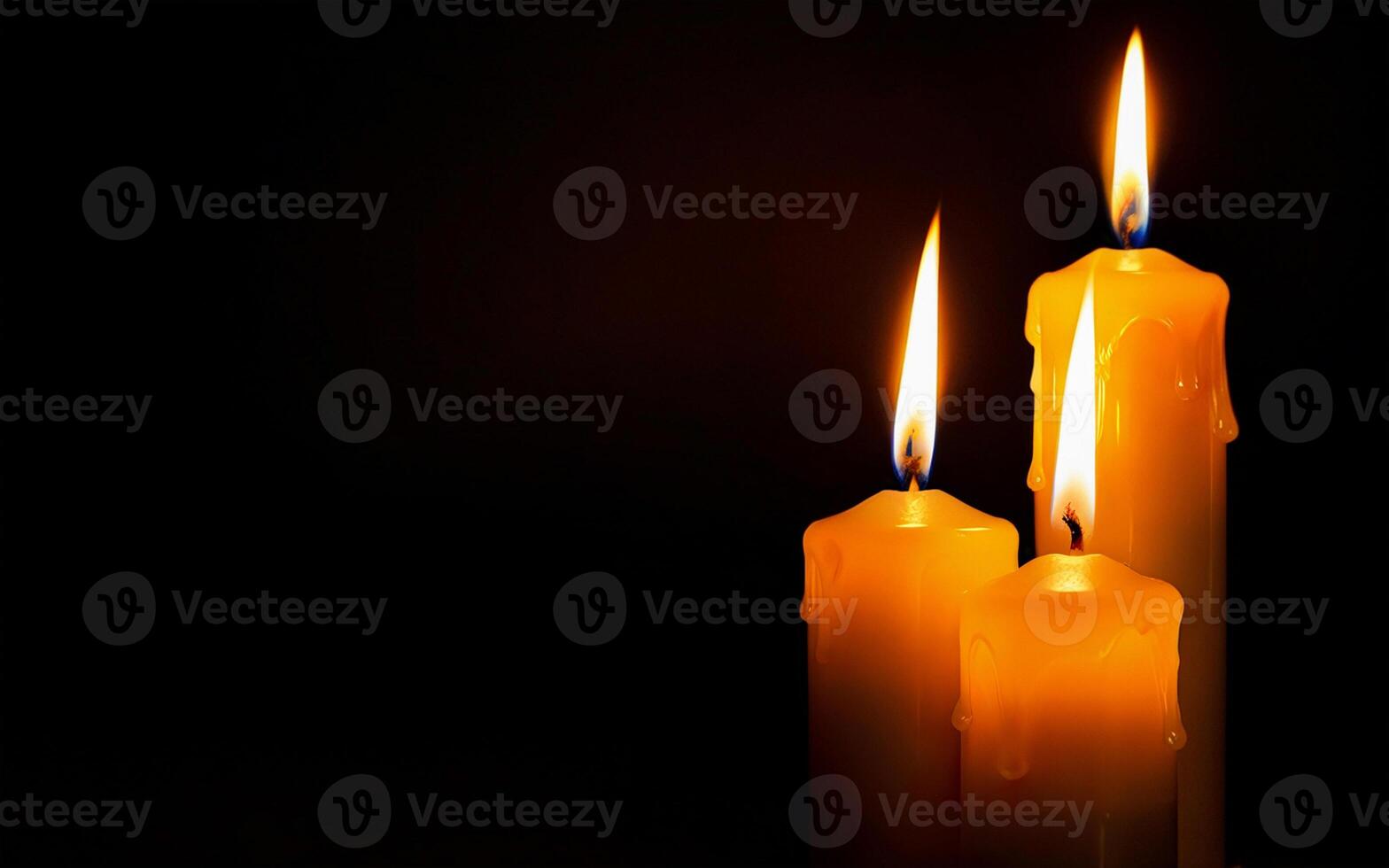 yellow burning candles with dripping wax close-up on a black background with space for text photo