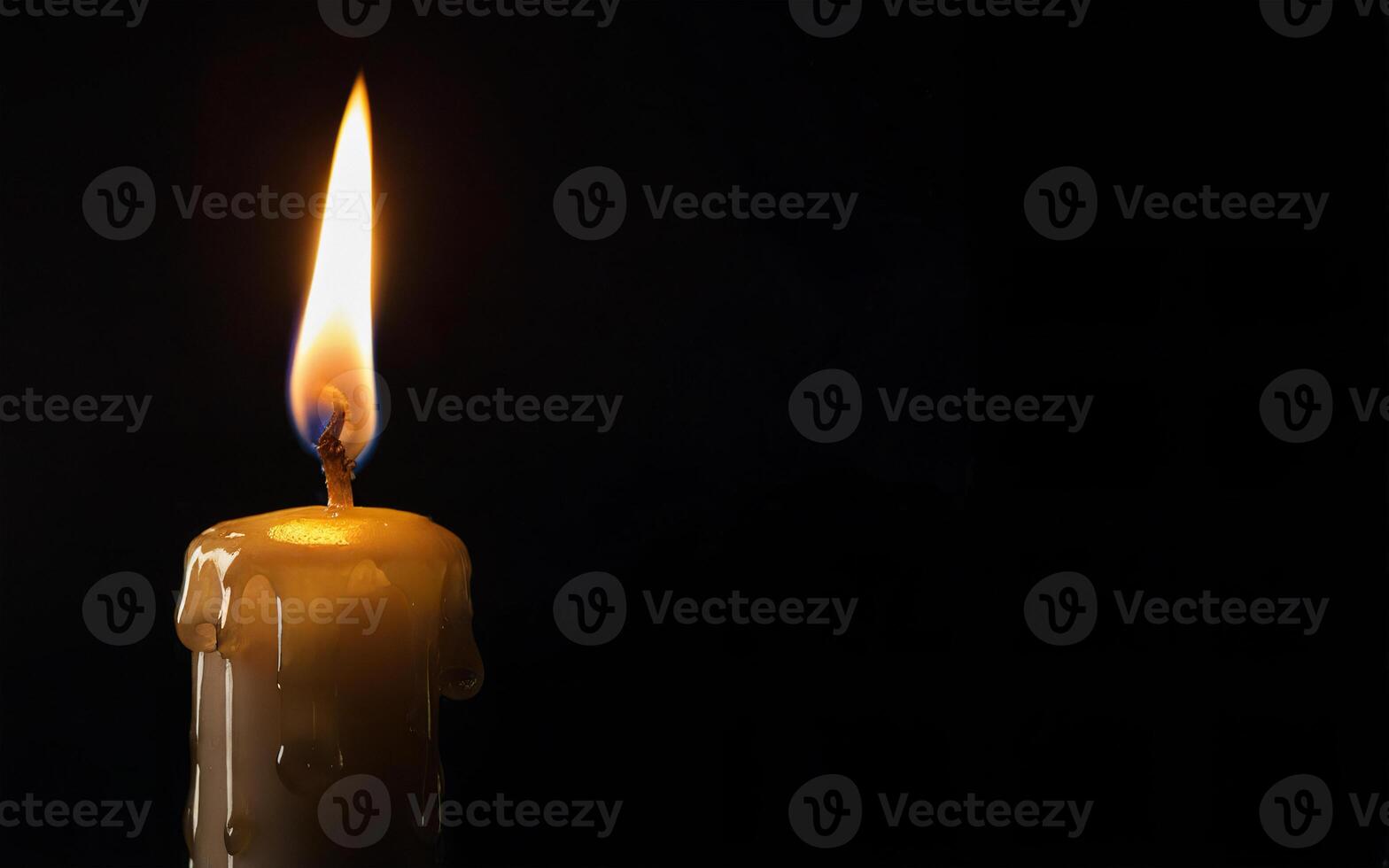 burning candle and dripping wax on a black background with space for text photo