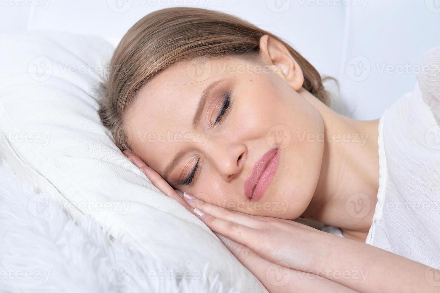 Portrait of young woman sleeping in bed at home photo