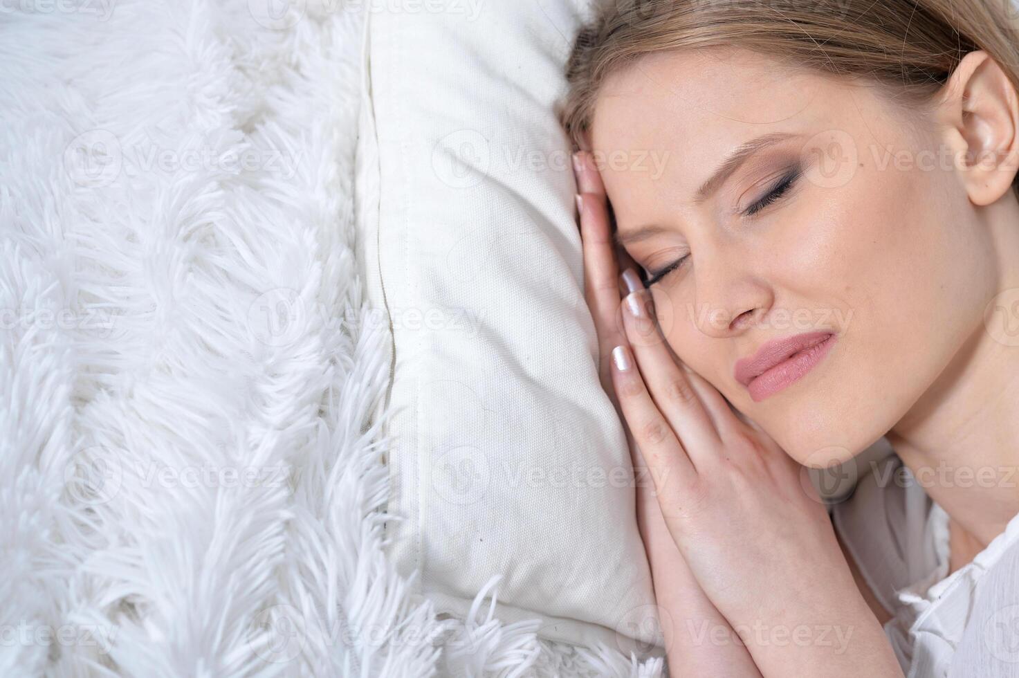 Portrait of young woman sleeping in bed at home photo